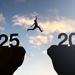 Silhouette Man jumping from 2025 cliff to 2026 cliff with cloud sky